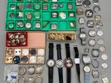 de nombreuses montres de toutes sortes, ainsi que des montres rangées dans une boîte posée sur une table