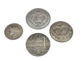 four different types of silver coins on a white surface