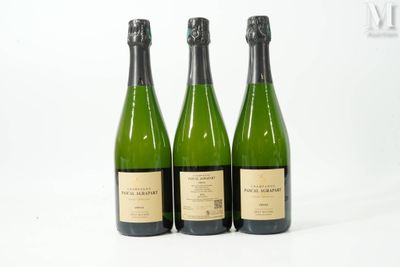 trois bouteilles de vin posées les unes à côté des autres sur une surface blanche