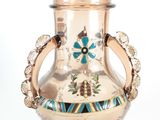a gold vase with a blue and green design on it