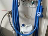 a blue hose attached to the wall next to a canister of water