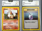 two pokemon cards are shown in plastic cases on a table
