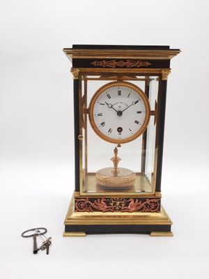 une horloge posée sur une table à côté d'une clé