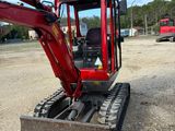 an image of a small red excavator parked in a lot