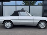 an image of a silver convertible car parked in front of a building