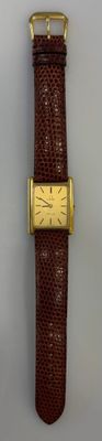 une photo d'une montre en cuir marron avec un cadran plaqué or