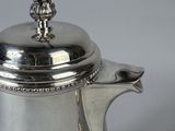 silver plated coffee pot with a lid on a white surface