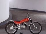 a red motorcycle parked in a parking garage next to a wall