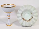 a white and gold cup and saucer sitting next to each other