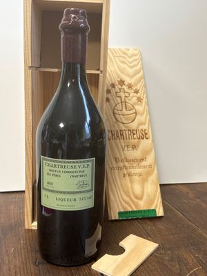 une bouteille de vin posée sur une table à côté d'une caisse en bois
