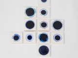 des sous-verres bleus et blancs en forme d'œil sur un fond blanc