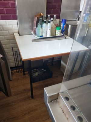 une petite table sur laquelle sont posées de nombreuses bouteilles