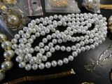a lot of pearls and other jewelry on a table