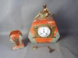 une petite horloge surmontée d'une statue