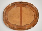 an old wooden frame with a round design on it