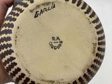a person holding a plate with a black and white design