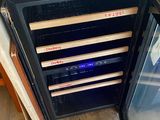 a wine cooler with a lot of bottles in it