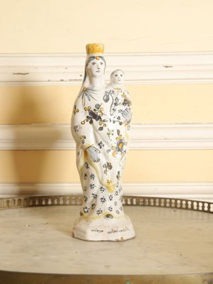 une figurine représentant une femme tenant un oiseau, posée sur une table