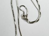 silver plated necklace with a pendant on a chain on a white surface