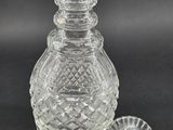 a clear glass bottle with a lid and a small glass stopper