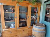 a wooden cabinet with glass doors and a wooden barrel on the floor