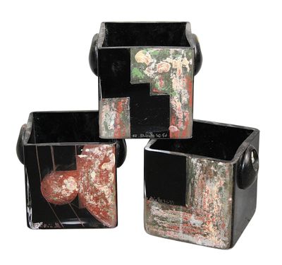 three black and red vases sitting next to each other