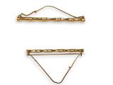 a pair of gold hair clips on a white background