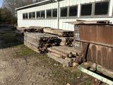a train car that is sitting next to a pile of wood