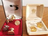 two pairs of cufflinks in a box on a table