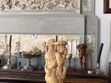 a statue on a table in front of a fireplace