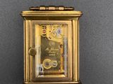 an image of a gold clock on a black surface