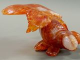 sculpture of a fish made out of a shell on a gray surface