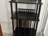 une étagère noire qui se trouve dans un coin de la pièce