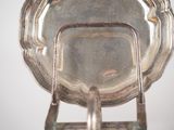 a silver plate with a handle on a stand