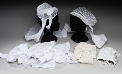 deux mannequins noirs vêtus de vêtements blancs et portant un chapeau blanc