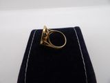 a close up of a gold ring on a black velvet case