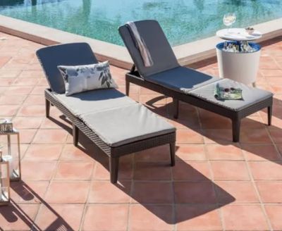 deux chaises longues et une table près d'une piscine