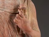 an old statue of a woman holding a flower in her hand