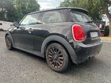 a small black car parked on the side of the road