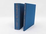 two blue books sitting on top of each other on a white surface