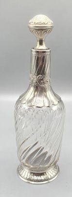 une image représentant un flacon de parfum en argent et en verre sur fond blanc