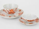 deux tasses et soucoupes ornées de fleurs orange sur fond blanc