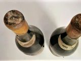 two bottles of wine sitting next to each other on a table