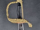 a close up of a sword with a gold handle