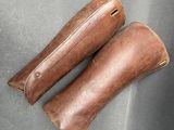 une paire de bottes d'équitation en cuir marron posées sur une surface grise