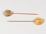 pair of gold - plated hair pins with a face of a man and a woman