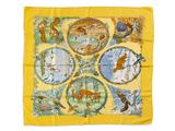 L'écharpe jaune est ornée d'un motif représentant des animaux et des oiseaux.