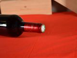 a bottle of wine sitting on a table with a red cloth