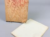un vieux livre posé sur une table à côté d'une feuille de papier