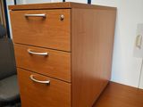 une image représentant un bureau en bois avec des tiroirs et une chaise